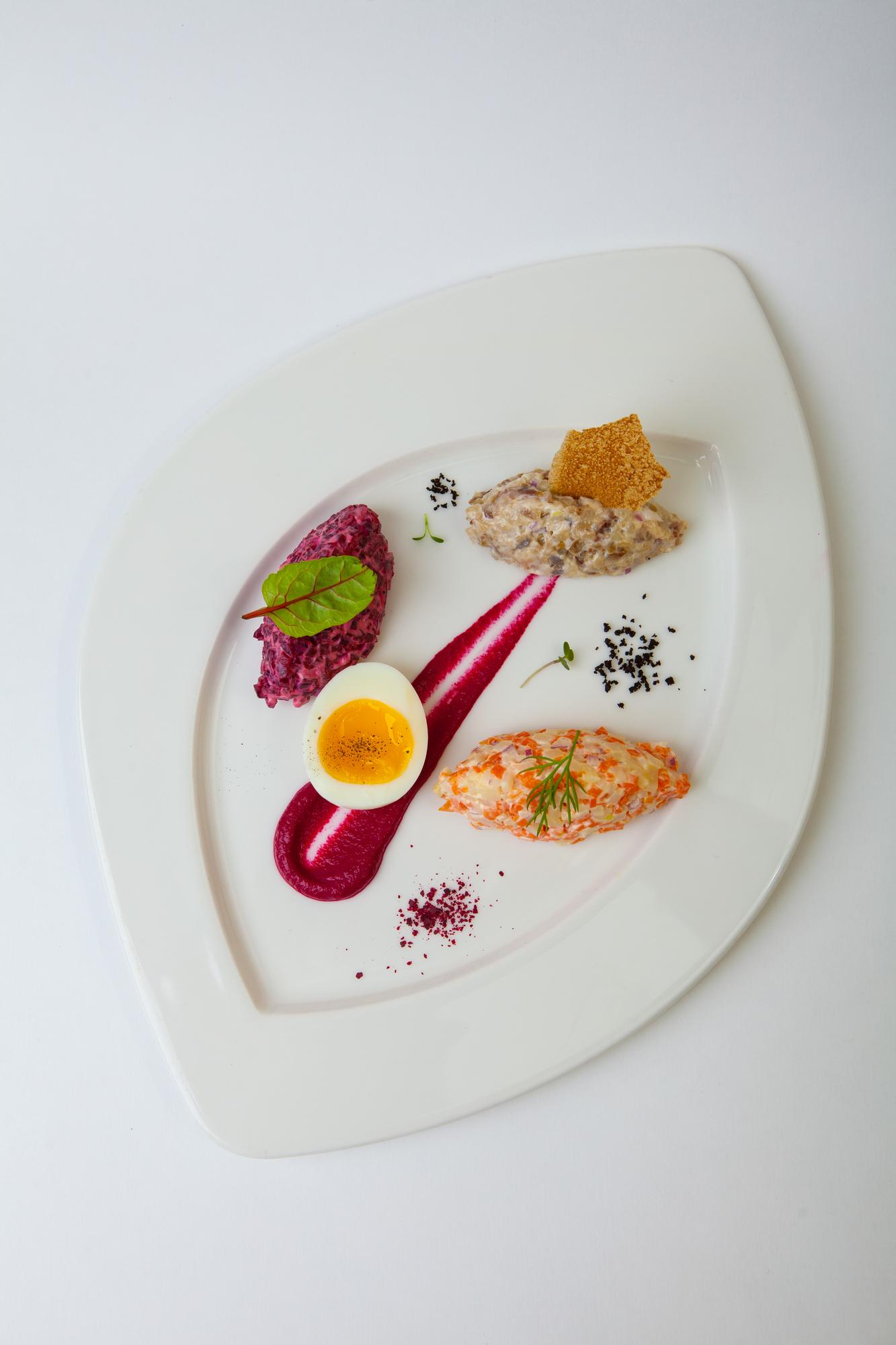 A chef arranging plated dish in calm studio